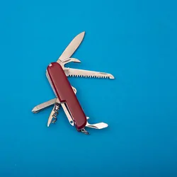A red color Swiss Army knife on a blue background