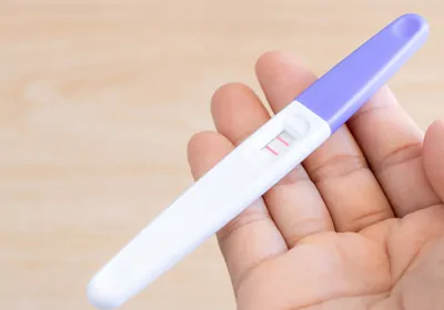 A close-up of a positive pregnancy test with two red lines, indicating the presence of hCG antibodies
