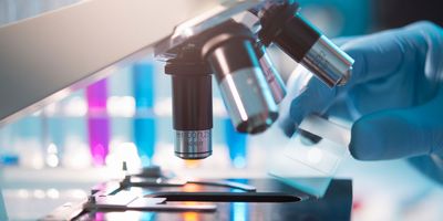 A scientist placing a slide under a microscope