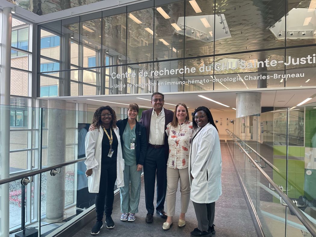 A group of clinical researchers from Taysha Gene Therapies REVEAL trial for Rett syndrome stand in a row inside of a research building.