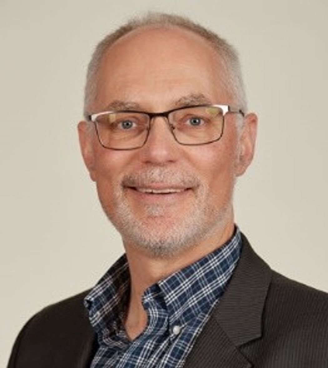 Chris Stumpf, Director of Drug Discovery Informatics Solutions, wearing black square glasses, a blue and white checked button-up shirt, and a dark grey blazer against a beige background in a professional headshot. Chris Stumpf, Director of Drug Discovery Informatics Solutions, wearing black square glasses, a blue and white checked button-up shirt, and a dark grey blazer against a beige background in a professional headshot.