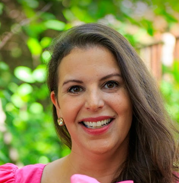 Blair Kerr in a pink blouse smiling confidently in an outdoor setting. Blair Kerr in a pink blouse smiling confidently in an outdoor setting.