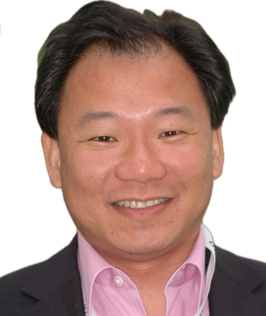 A headshot of Victor Chong smiling and wearing a black suit and pink shirt. A headshot of Victor Chong smiling and wearing a black suit and pink shirt.