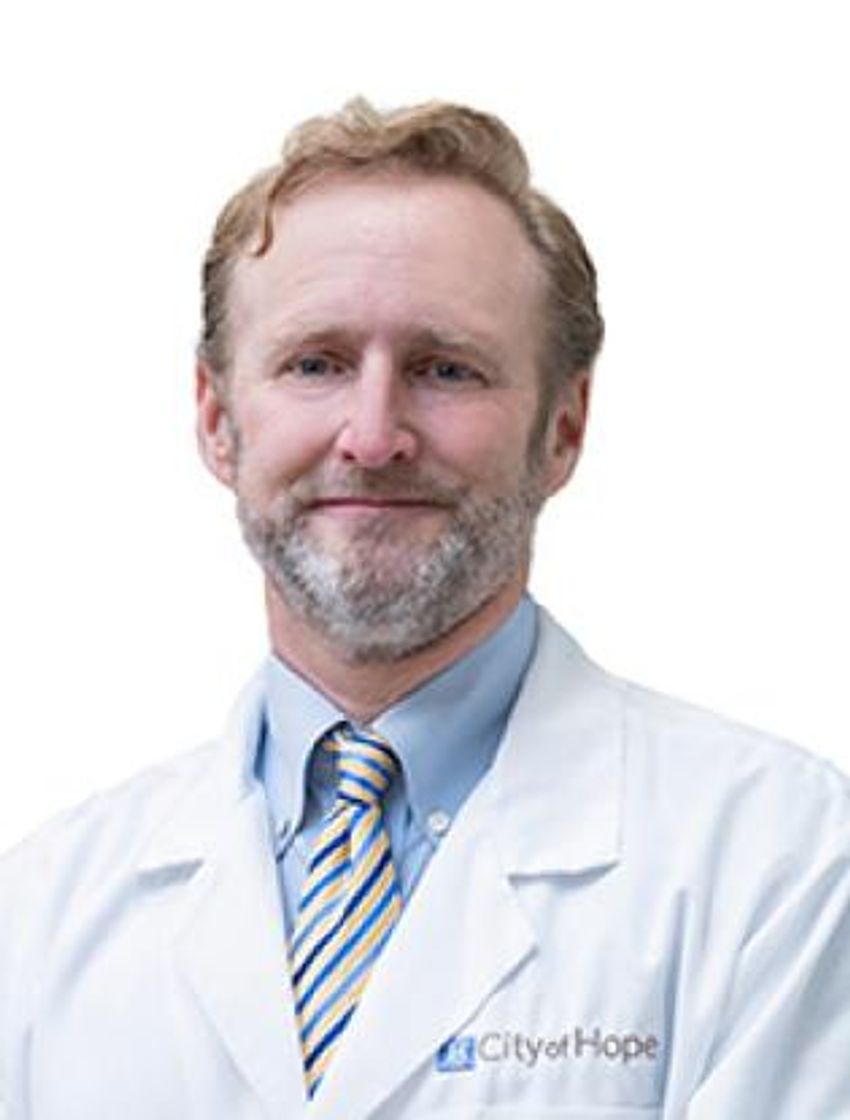 David Craig wears a white coat with a blue shirt and tie and smiles. David Craig wears a white coat with a blue shirt and tie and smiles.