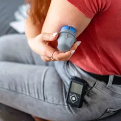A woman with an insulin pump takes a blood reading. 