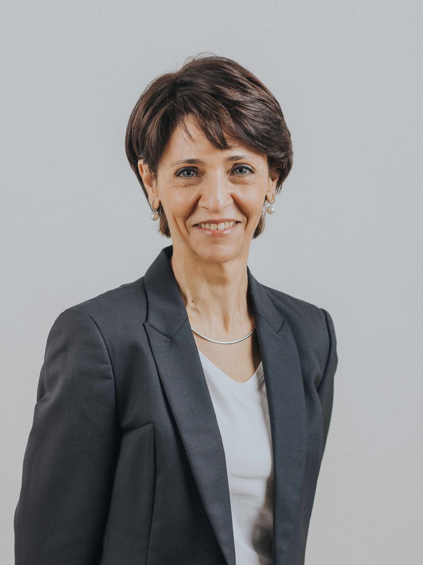 Yolanda Sanz wears a dark jacket over a white shirt in a headshot. Yolanda Sanz wears a dark jacket over a white shirt in a headshot.