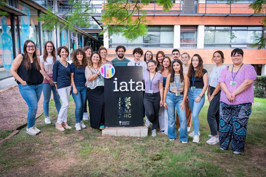 A group of laboratory researchers stand outside on the grass. A group of laboratory researchers stand outside on the grass.