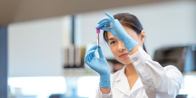 Scientist examining a blood sample in a lab for cancer biopsy testing.