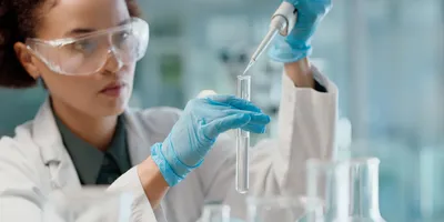 Scientist in lab using pipette for liquid testing in research on oral formulation technologies.