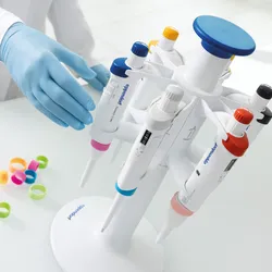 Gloved hand reaching for research3 neo pipettes on pipette stand 