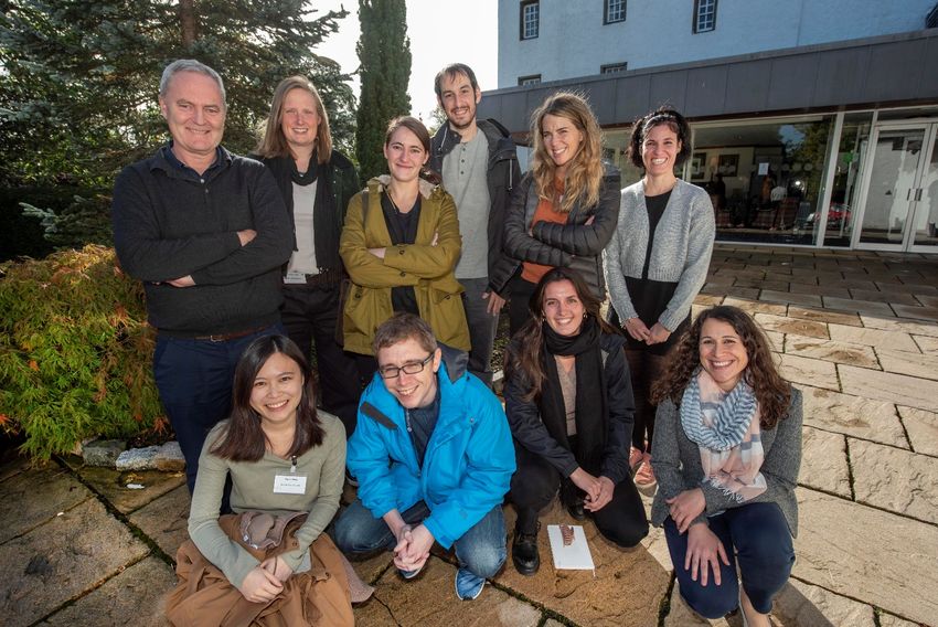 A group of scientists posing for a photo outside a research institute.