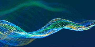 Abstract digital wave made of colorful wireframe mesh lines in blue, green, and yellow on a dark background.