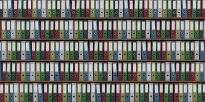 Big archive full of colored office binders representing the huge amount of data generated by clinical trials. 