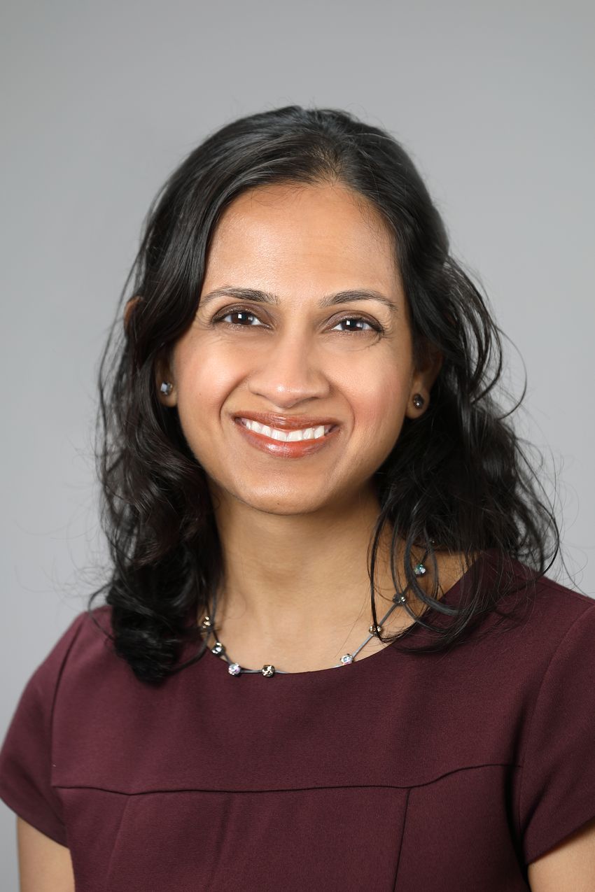 A portrait of a woman wearing maroon shirt and a beaded necklace A portrait of a woman wearing maroon shirt and a beaded necklace