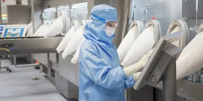 A person in protective clothing in a biologics lab