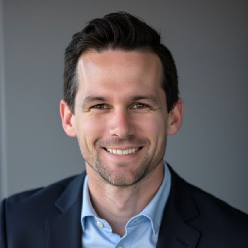 Cameron Ferris in a suit, smiling into the camera