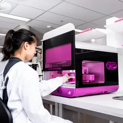 A scientist in lab PPE using the RASTRUM™ Allegro platform