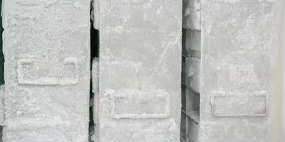 Frozen storage boxes covered in frost inside a laboratory freezer.