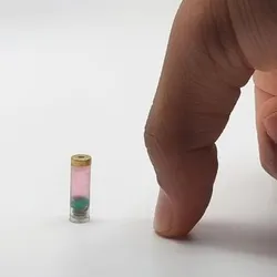 A person pointing at a swallowable bioprinter capsule
