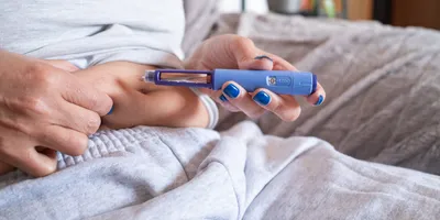 mature overweight diabetic woman injecting a syringe of semaglutide into her belly.