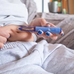 mature overweight diabetic woman injecting a syringe of semaglutide into her belly.