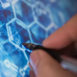 Close-up of a researcher using a stylus to draw or interact with digital molecular structures on a blue scientific interface.