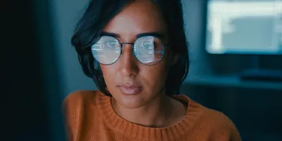 Female computer programmer works on complex software development tasks at her home office late into the night. Software developer, artificial intelligence and programming concept.