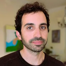 Headshot of Max in a brown sweater