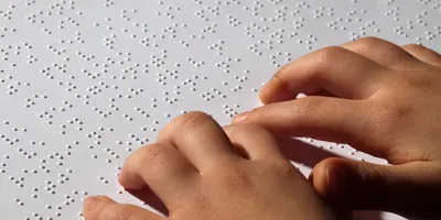 A young, blind girl reading braille