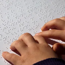 A young, blind girl reading braille