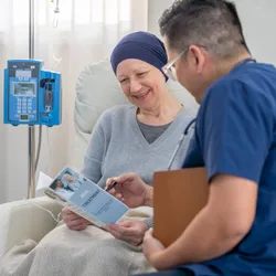 A male nurse of Asian decent, makes his way around to cancer patients as he check in on them during their Chemotherapy treatments.