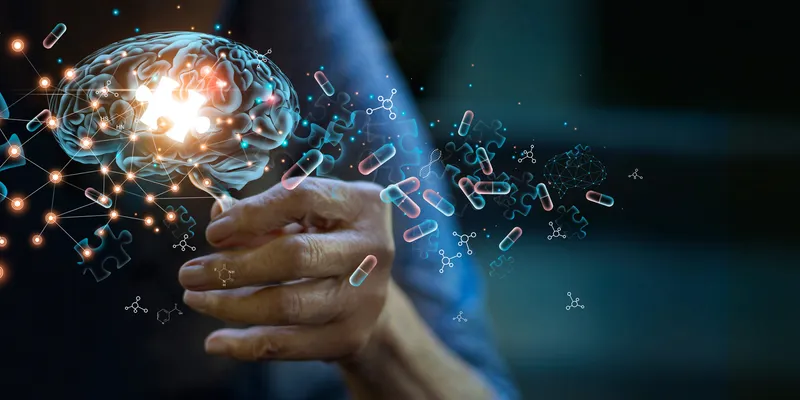 A transparent human brain is shown with a lit up puzzle piece in the middle and floating pills around it.