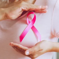 Woman shows pink ribbon as sign of Breast Cancer Awareness.
