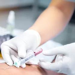 Taking a blood sample from a patient in the hospital.