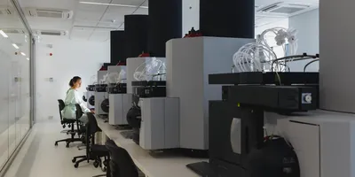 A female scientist sits amid large machinery in a leading research center.