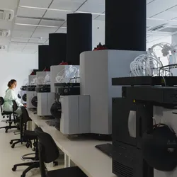 A female scientist sits amid large machinery in a leading research center.