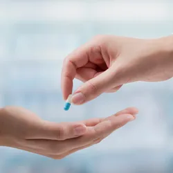 Professional doctor giving a prescription medicine to a patient.