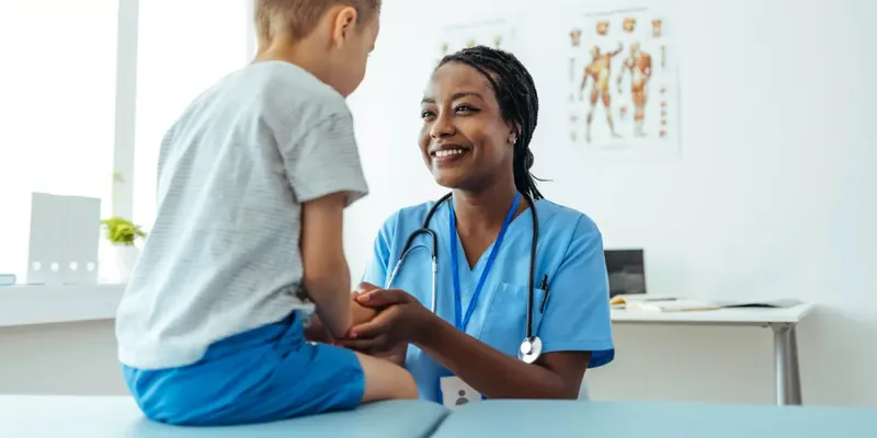 Healthcare professional engaging with a child patient in a medical setting.