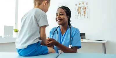 Healthcare professional engaging with a child patient in a medical setting.
