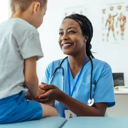 Healthcare professional engaging with a child patient in a medical setting.
