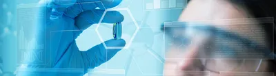 Scientist holding a pill behind a scientific blue screen