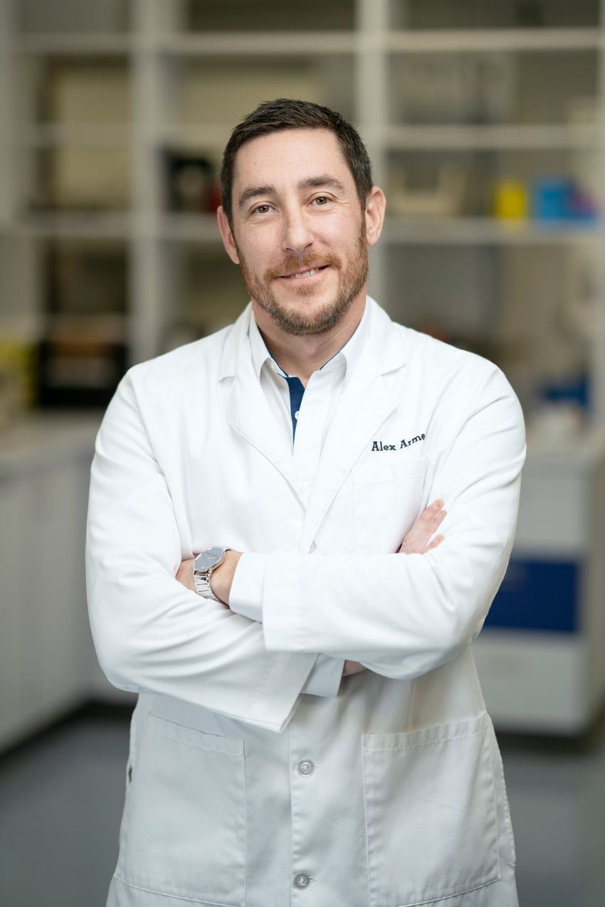 Alex Armento wearing a lab coat in a lab setting.