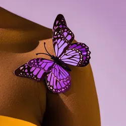 Cropped view of African American woman with purple butterfly on shoulder.