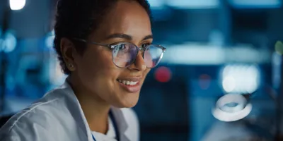 Young, female scientist looks at computer screen.