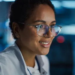 Young, female scientist looks at computer screen.