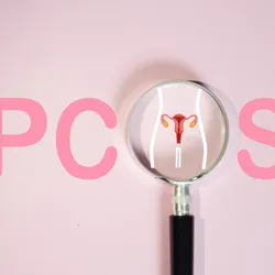 Pink background with the word PCOS, with a magnifying glass over a diagram of ovaries where the O would be. 