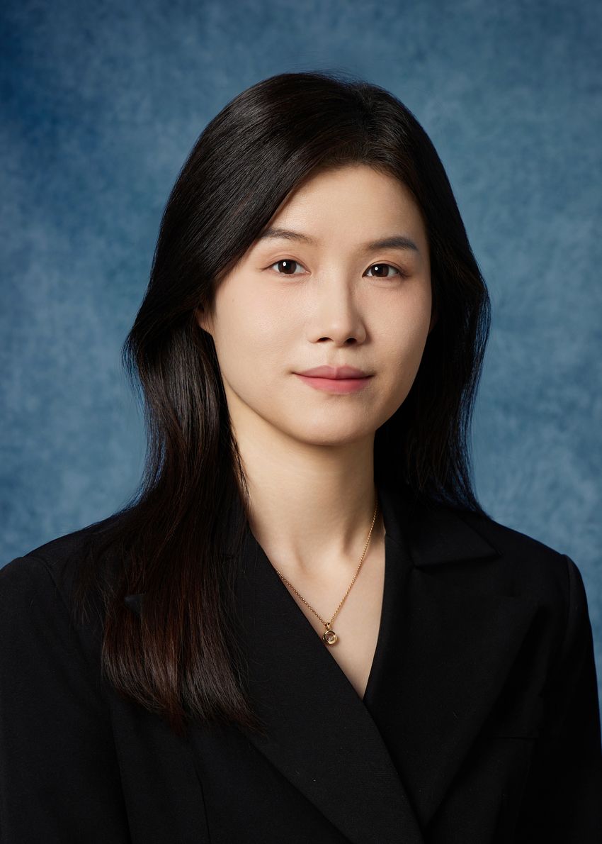 A headshot of Jie Ma, wearing a black blazer.