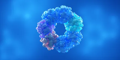 3D illustration of a protein complex composed of clustered spherical subunits arranged in a ring-like oligomeric structure, shown in shades of blue, cyan, and purple against a blue gradient background.