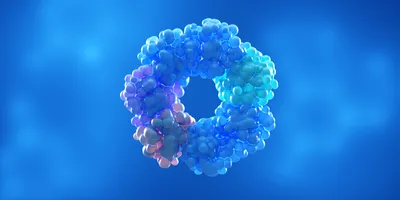 3D illustration of a protein complex composed of clustered spherical subunits arranged in a ring-like oligomeric structure, shown in shades of blue, cyan, and purple against a blue gradient background.