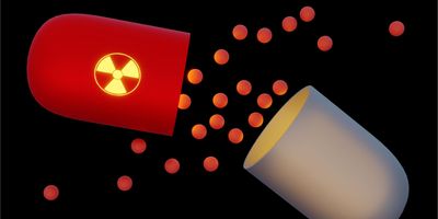 Illustration of a radioactive capsule releasing glowing particles against a black background. 